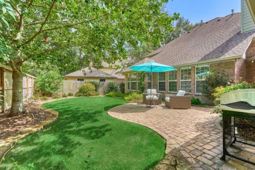 a patio with an umbrella and a lawn at New!4BR with Easy Access to all Woodlands Amenities in The Woodlands