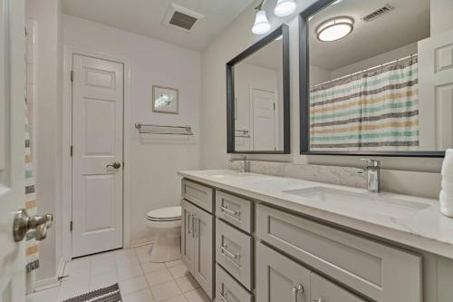 a bathroom with a sink and a toilet and a mirror at New!4BR with Easy Access to all Woodlands Amenities in The Woodlands