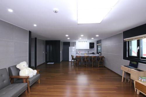 a living room with a teddy bear sitting on a couch at Uljin Blue Ara B pension in Uljin