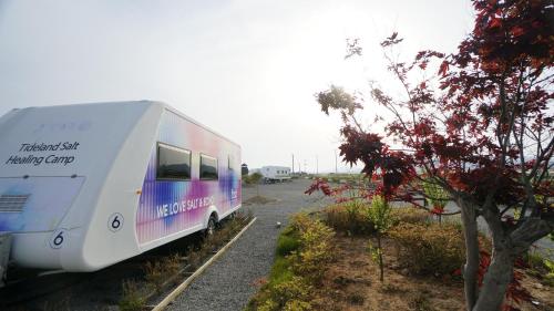 a white trailer parked in a parking lot at Sinan Solar Salt Healing Camp Caravan in Sinan