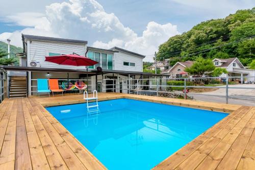 a swimming pool on a deck with a house at Marine Pension Paju in Paju