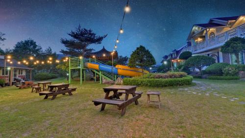 a park with picnic tables and a slide at night at Kapyeong Ilsang Talchul Pension Water Slide in Gapyeong