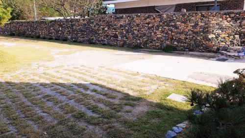 a stone walkway in front of a stone wall at Buan sukranjeong pension in Buan