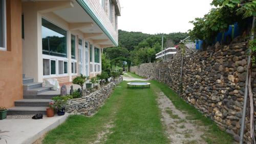 a building with a bench next to a stone wall at Buan sukranjeong pension in Buan