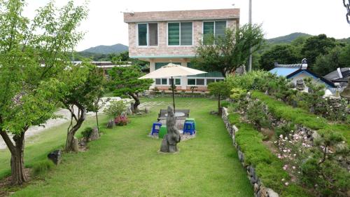 a garden with statues in front of a building at Buan sukranjeong pension in Buan