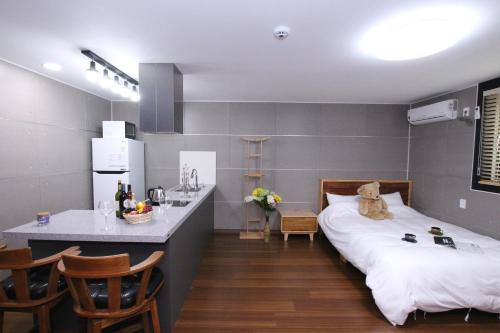 a room with a bed and a kitchen with a counter at Uljin Blue Ara CD pension in Uljin