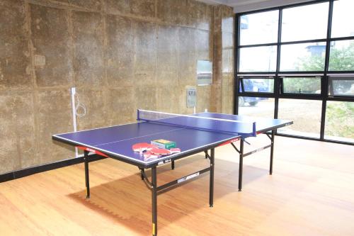 a blue ping pong table in a room with windows at Uljin Blue Ara CD pension in Uljin