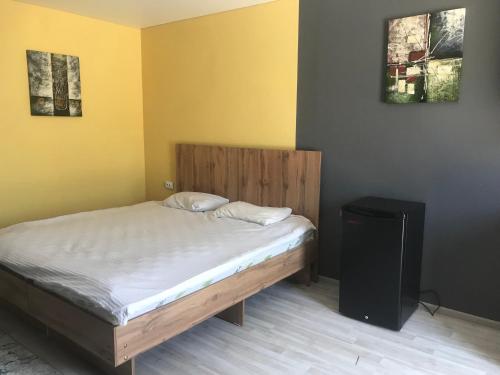 a bedroom with a bed with a wooden headboard at D&N Karakol in Karakol