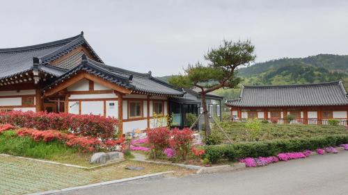 a house with a garden with flowers in front of it at Boseong Greenery Hanok Pension in Boseong