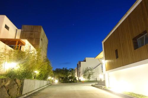 an empty street between two buildings at night at Seogwipo Smart Pool Villa in Seogwipo