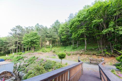 茂朱Muju Sky View Pension的木甲板上设有长凳和树木