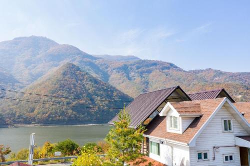 a house with a view of a river and mountains at Moojoo Jeonmangdae Pension in Muju