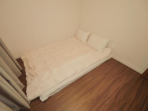 a white couch in a corner of a room at Chuncheon Kerensia Pension in Chuncheon