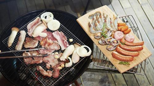 two pans with different types of meat and vegetables at Gapyeong Cheotnooneh Pension in Gapyeong