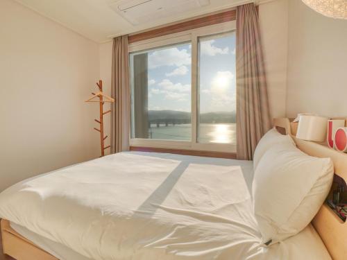 a bedroom with a large bed and a window at Chuncheon Kerensia Pension in Chuncheon