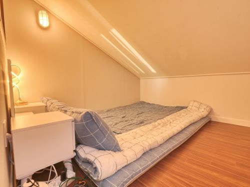 a small bedroom with a bed in the corner at Chuncheon Kerensia Pension in Chuncheon