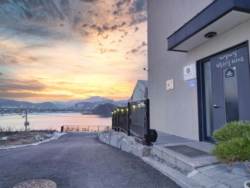 a building with a sunset in the background at Chuncheon Kerensia Pension in Chuncheon