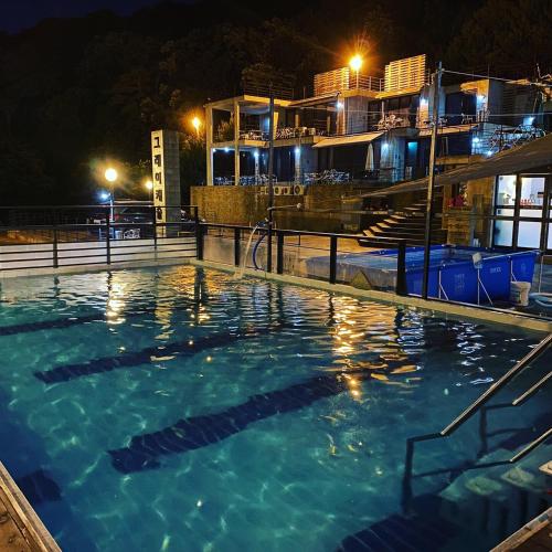 a large swimming pool at night with buildings in the background at Yangju Gray Castle Pension in Yangju
