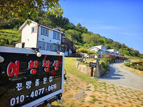 a sign in front of a house on a hill at Jeonnam Cheongsando Yeohaeng Pension in Wando
