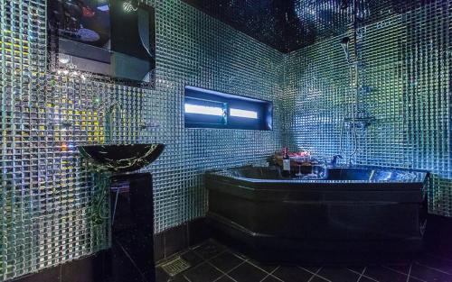 a green tiled bathroom with a tub and a sink at Chuncheon Pier Star Pension in Chuncheon