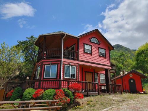 a red house with flowers in front of it at Danyang mulgoeul pension in Danyang