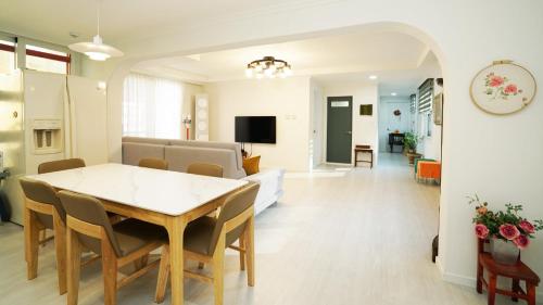 a dining room and living room with a table and chairs at Gangchon Nutinamu Maeul Pension in Chuncheon