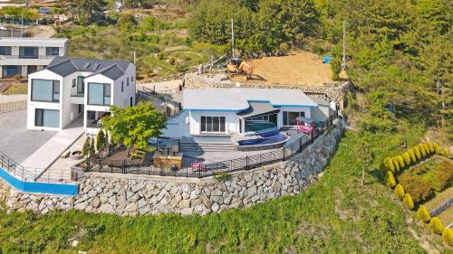 eine Luftansicht eines Hauses an einer Steinmauer in der Unterkunft Namhae Bokkongii Seesru Ocean View Poolvilla in Namhae