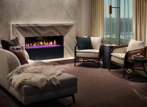 a living room with a fireplace and two chairs at Omni Viking Lakes in Eagan