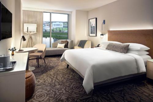 a bedroom with a large bed and a living room at Omni Viking Lakes in Eagan