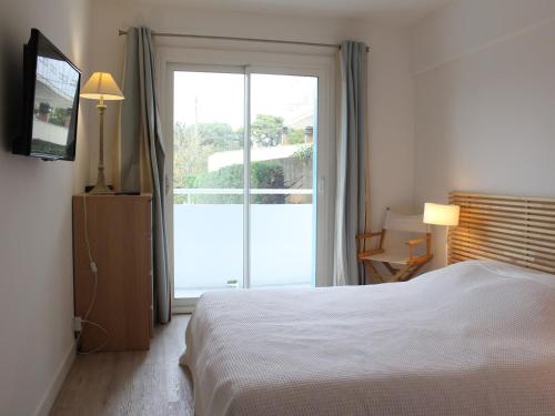 une chambre avec un lit et une porte coulissante en verre dans l'établissement Moderne 3P avec terrasse, face mer, La Baule - FR-1-245-209, à La Baule