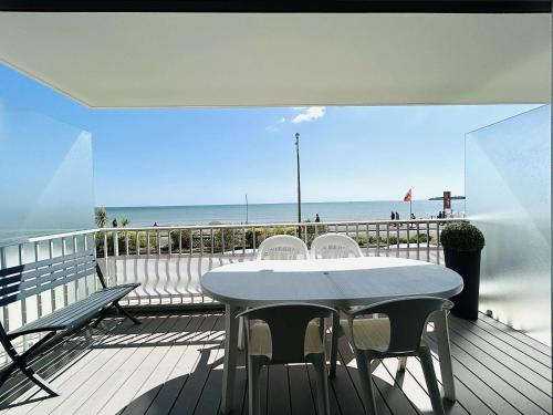 une table et des chaises sur un balcon avec vue sur la plage dans l'établissement Moderne 3P avec terrasse, face mer, La Baule - FR-1-245-209, à La Baule