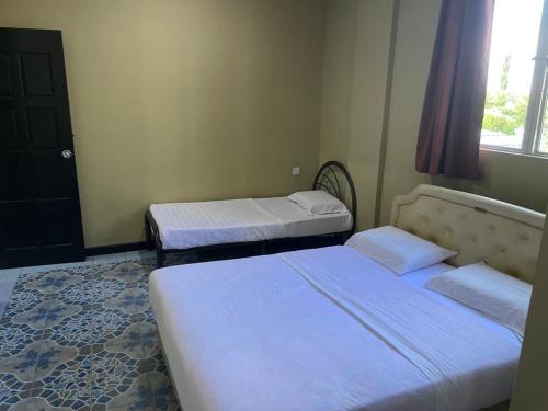 a bedroom with two beds and a window at Tabin Lodge Budget Stay in Lahad Datu
