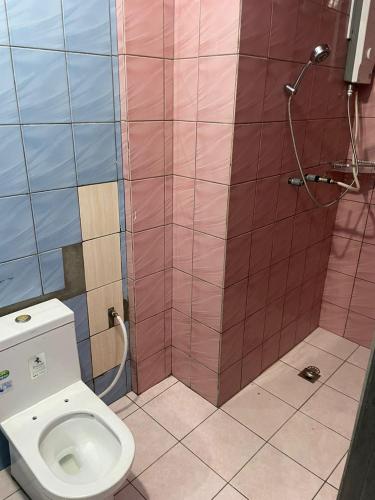 a bathroom with a toilet and a shower at Tabin Lodge Budget Stay in Lahad Datu