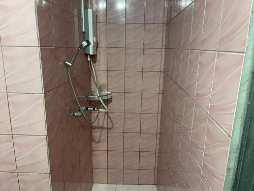 a shower in a bathroom with a brown wall at Tabin Lodge Budget Stay in Lahad Datu