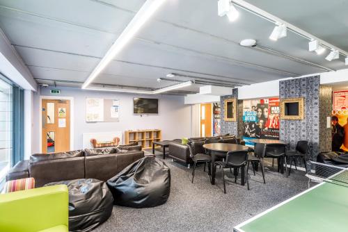 a waiting room with couches and tables and chairs at Destiny Student – Murano (Campus Accommodation) in Edinburgh