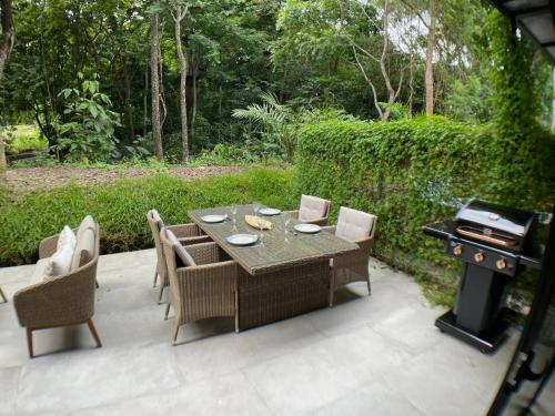 a patio with a table and chairs and a grill at 2Bdr Condo - Los Delfines Golf & Country Club - Large Patio - Beach of Playa Tambor - 24 hrs security in Pochote