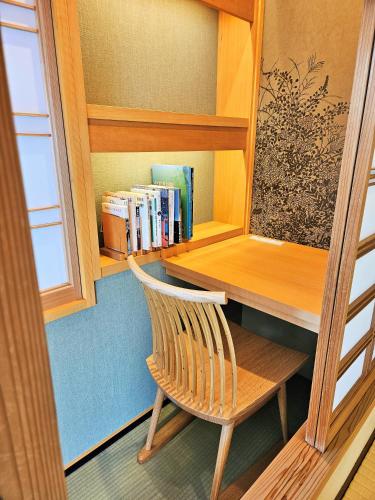 a library with a wooden desk and a chair at Saginoyusou in Yasugi