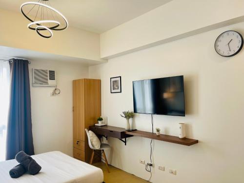 ein Schlafzimmer mit einem Bett und einem Fernseher an der Wand in der Unterkunft Peaceful Studio Unit at Centrio Tower beside Ayala Mall in Cagayan de Oro