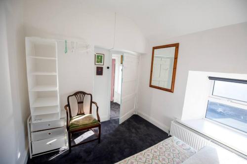 a white room with a chair and a mirror at Newly renovated entire residential home Annestown Beach, County Waterford in Annestown
