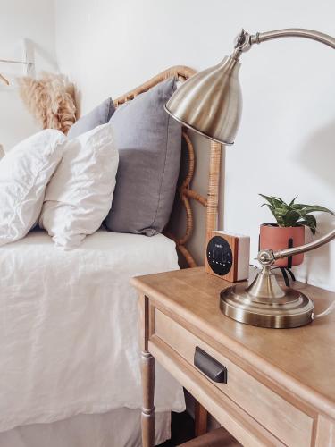 a lamp on a table next to a bed with pillows at Guesthouse on Girod in Mandeville
