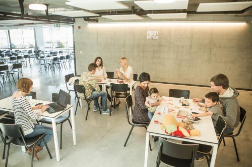 um grupo de pessoas sentadas em mesas em uma sala de aula em Hostel H em Hasselt