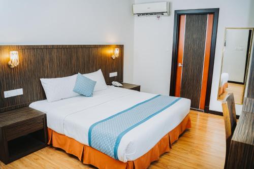 a bedroom with a large bed in a room at Hotel Nur Miri in Miri