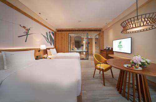 a hotel room with a bed and a table at Holiday Inn Jilin Beidahu by IHG in Jilin