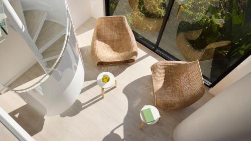 two wicker chairs and a table on a balcony at Little Darling in Sydney