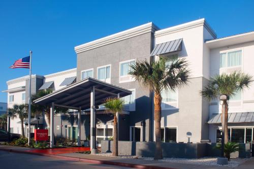 an office building with palm trees in front of it at TownePlace Suites by Marriott Galveston Island in Galveston
