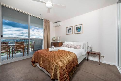 a bedroom with a bed and a balcony at Contemporary City Escape Phillip ACT in Phillip
