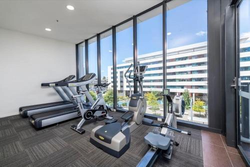 a gym with treadmills and ellipticals in a building at Sensational City Apartment with Lake Views in Canberra
