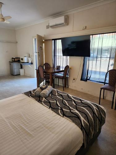 a bedroom with a large bed and a table with chairs at Inverell Motel in Inverell