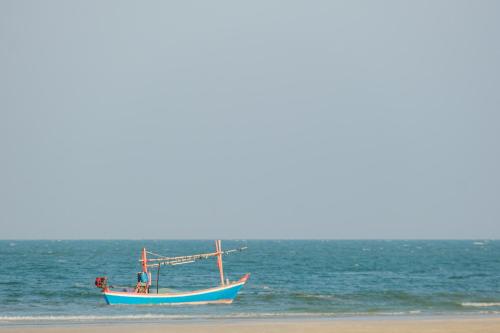a boat sitting on the beach next to a beach at Putahracsa Hua Hin in Hua Hin