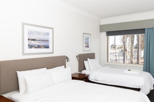 a hotel room with two beds and a window at Pastoral Hotel Motel in Port Augusta